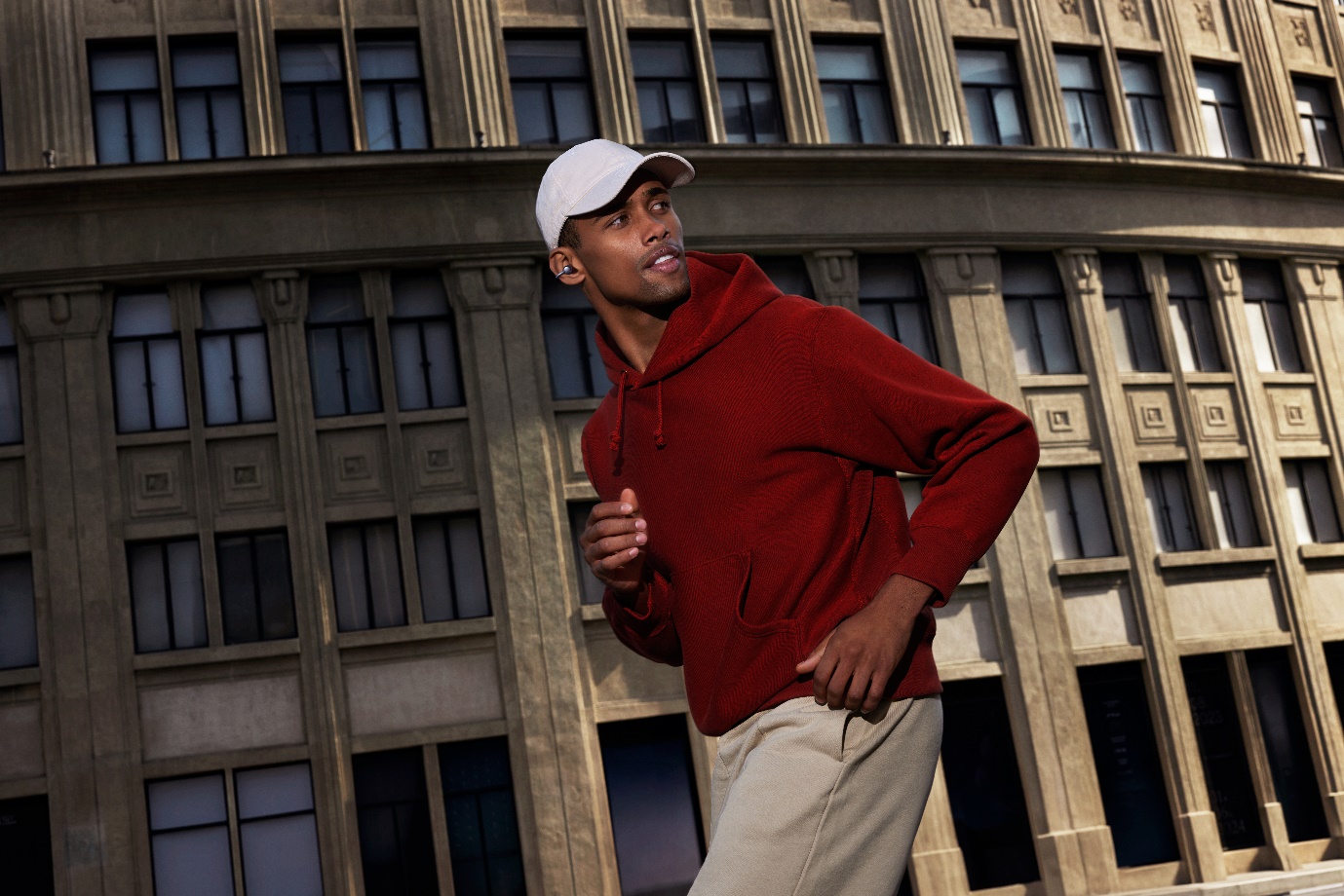 A person in a red hoodie and white cap  Description automatically generated